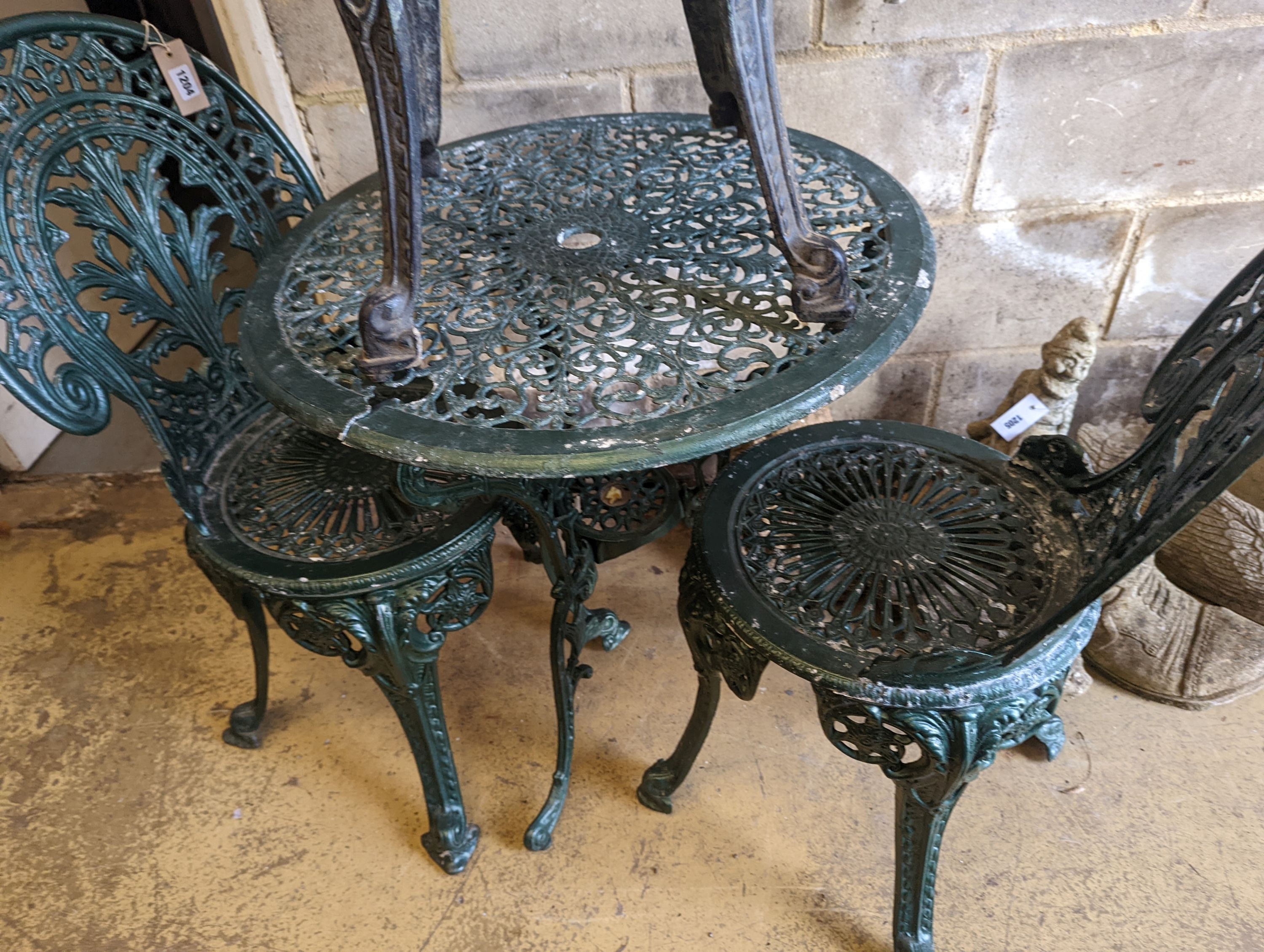 A circular painted aluminium garden table, diameter 65cm, together with three chairs